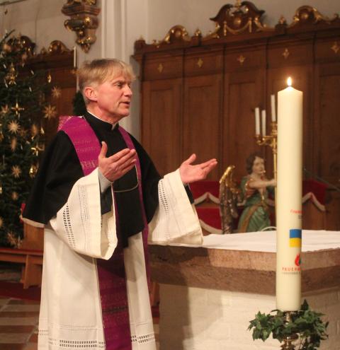 Pfarrer Gerhard Gumpinger segnet die Friedenslichtkerze